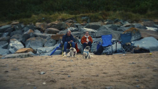 A couple on Porthdinllaen Beach, Gwynedd, in a National Trust advert about gifts in wills